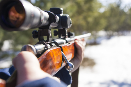 hunter looking down gun barrel practicing his aim