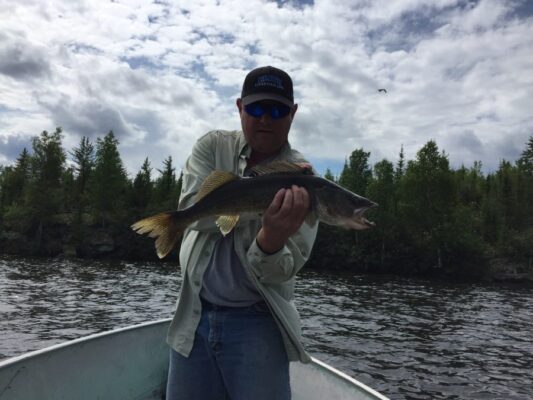 Man Showing off Fish from Reindeer Lake